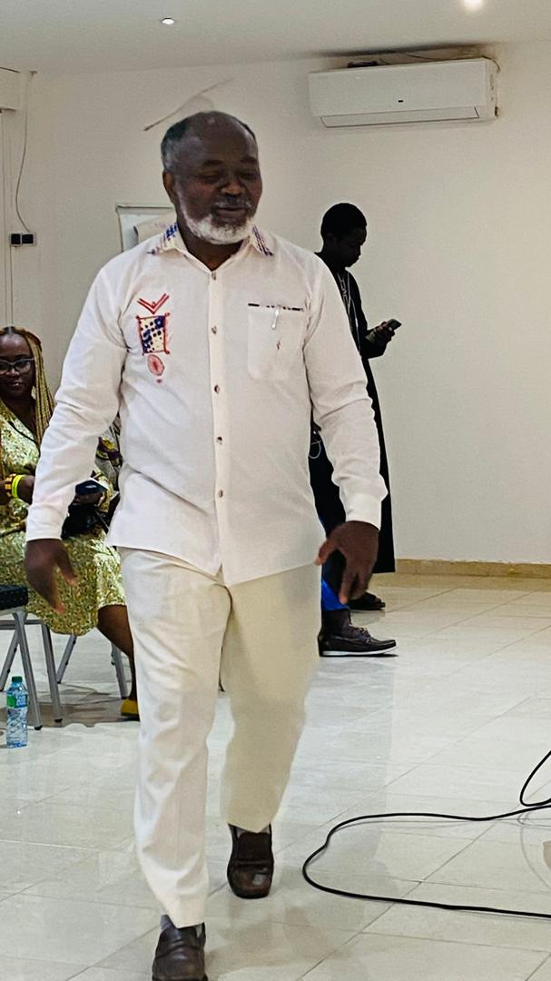 Le Dr Gnaka Lagoke portant une chemise blanche brodée lors d’une rencontre en intérieur