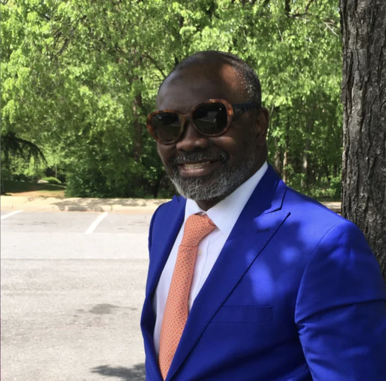 Dr. Gnaka Lagoke outdoors in a blue suit